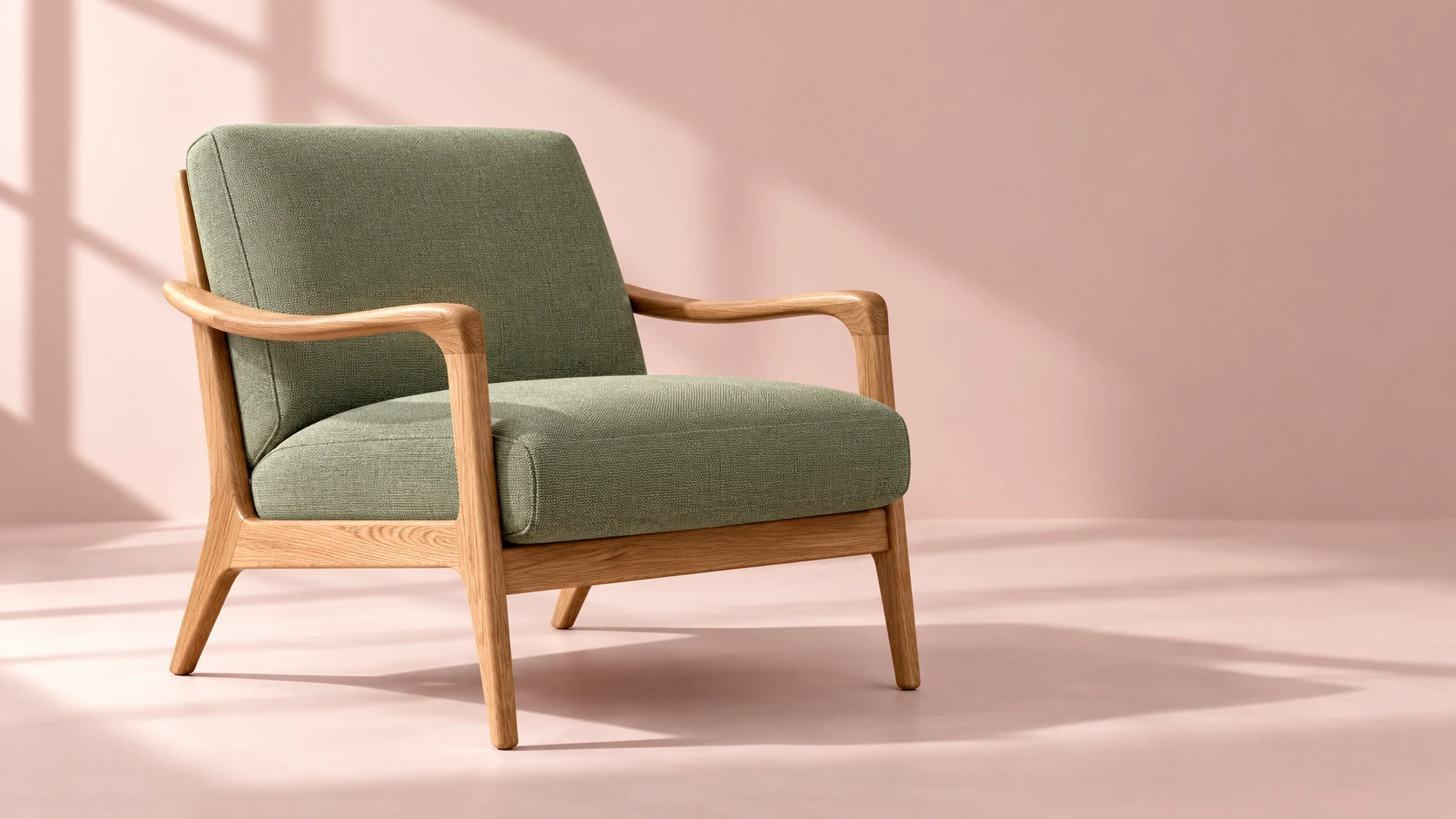 Sage lounge chair with oak armrests against a pale rose background